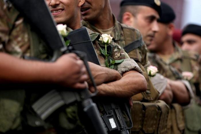 Lebanese soldiers wear white roses handed to them by protesters after they ignored pressure from the political establishment to reopen blocked roads, by force if necessary