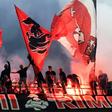 AC Milan fans wave flags during the city derby against Inter Milan in the San Siro stadium.