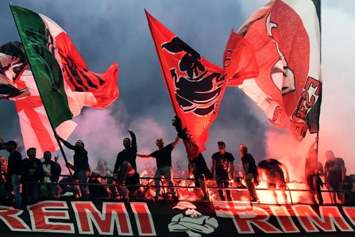 AC Milan fans wave flags during the city derby against Inter Milan in the San Siro stadium.
