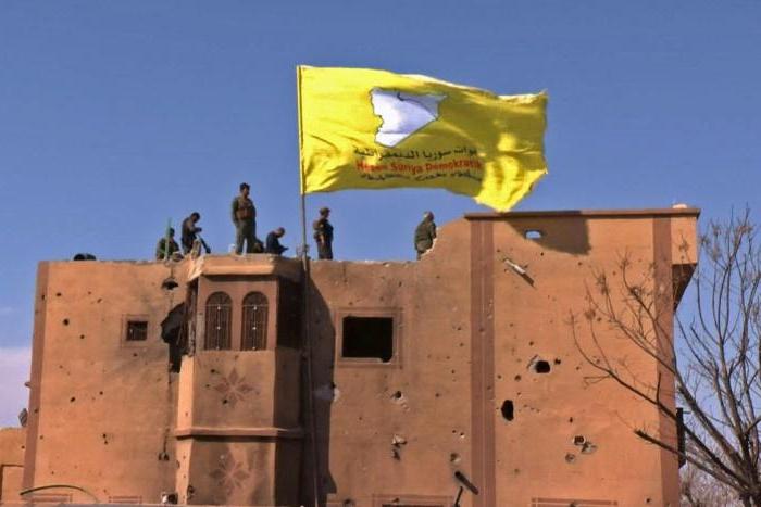 US-backed fighters of the Syrian Democratic Forces raise their flag in the Islamic State group's last redoubt of Baghouz as their commanders proclaim the total elimination of its "caliphate"
