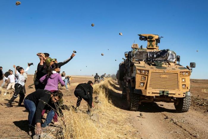A small group of people pelted the convoy with rocks and shoes as it drove by near the town of Maabda, close to the Turkish border
