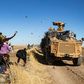 A small group of people pelted the convoy with rocks and shoes as it drove by near the town of Maabda, close to the Turkish border