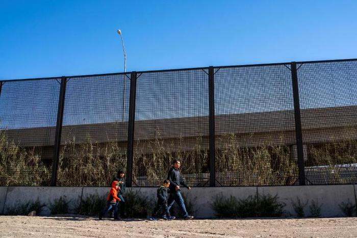 A family from El Salvador is pictured walking to turn themselves into Border Patrol agents after crossing the Rio Grande to claim asylum in El Paso, Texas