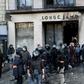 Riot police outside a partially burned Longchamps store on the Champs-Elysees in Paris on Saturday