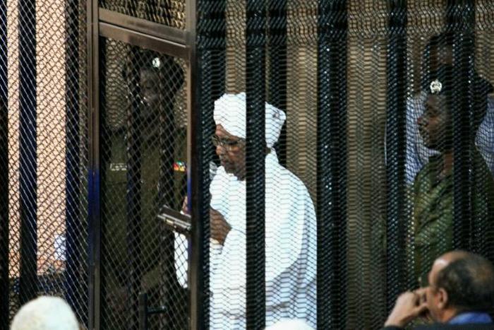Sudan's ex-president Omar al-Bashir (C) appears in court in the capital Khartoum to face charges of illegal acquisition and use of foreign funds