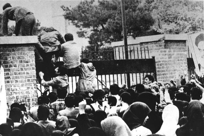 Iranian revolutionary students climb the American embassy's gate in Tehran on November 4, 1979 less than nine months after the toppling of the US-backed shah