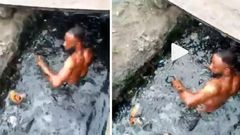 Angry soldier makes phone thief swim in a dirty gutter (video)
