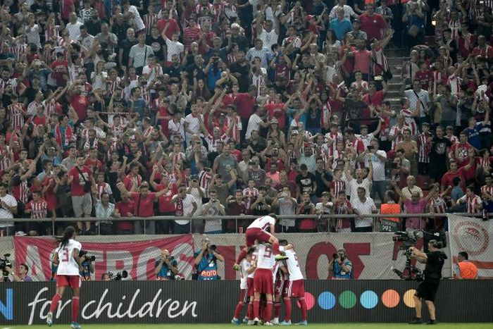 Olympiakos players and fans celebrate Mathieu Valbuena's equaliser against Tottenham