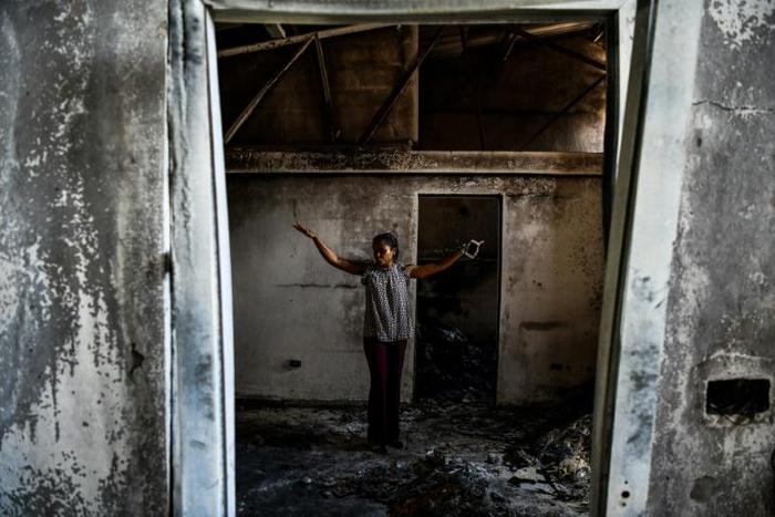 Magalie Noel Dresse, owner of the Caribbean Craft factory, walks through the remains of the factory in Port-au-Prince