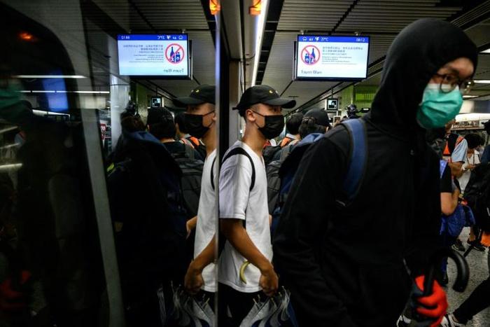 Protesters stood at doorways of trains, stopping them from closing, at a series of stations on the underground system