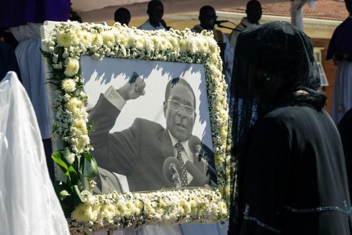 Former first lady Grace Mugabe walks past a portrait of Robert Mugabe during the burial of the former Zimbabwe leader at his home village in Kutama, west of the capital Harare