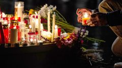 People leave candles and flowers at a vigil at the Marktplatz in Halle, eastern Germany