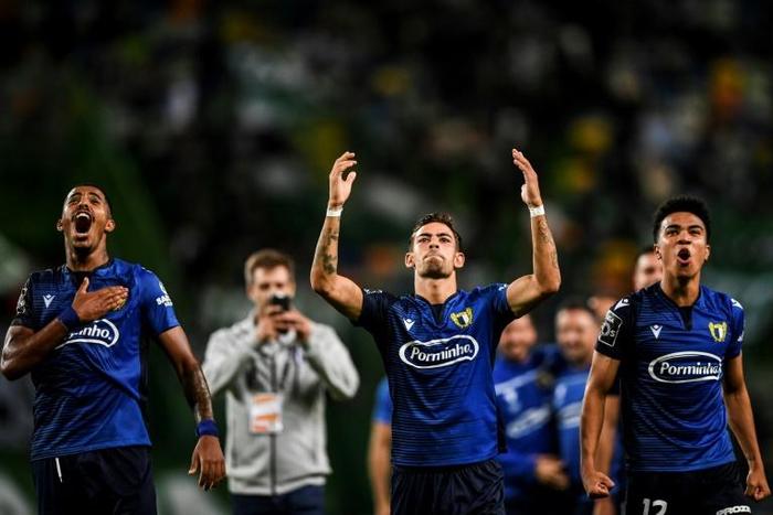 Famalicao players celebrate with fans after the club's victory over Sporting Lisbon on September 23