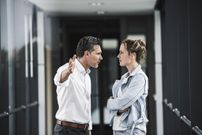 Businesswoman and businessman arguing in office passageway