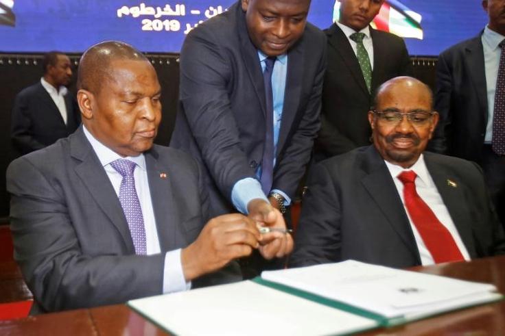 Central African Republic President Faustin-Archange Touadera, left, inks the peace deal next to Sudanese President Omar al-Bashir in Khartoum on February 5