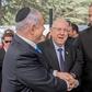 Israel President Reuven Rivlin watches on as opposition leader Benny Gantz shakes hands with Prime Minister Benjamin Netanyahu hours before laying claim to his job