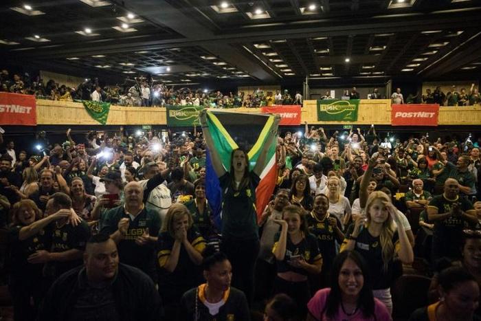 A woman (C) holds a South African flag as a crowd watches the Rugby World Cup final at a Johannesburg theme park last Saturday