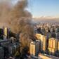 Smoke billows from a building on fire near where protesters were demonstrating in Santiago, on October 28, 2019