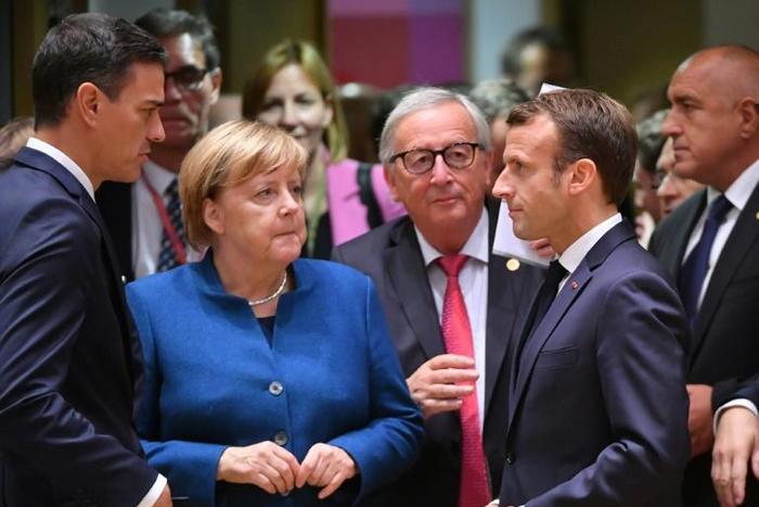 French President Emmanuel Macron (R, pictured October 2018), German Chancellor Angela Merkel (L) and European Commission president Jean-Claude Juncker (C) will meet with Chinese President Xi Jinping to discuss trade and climate