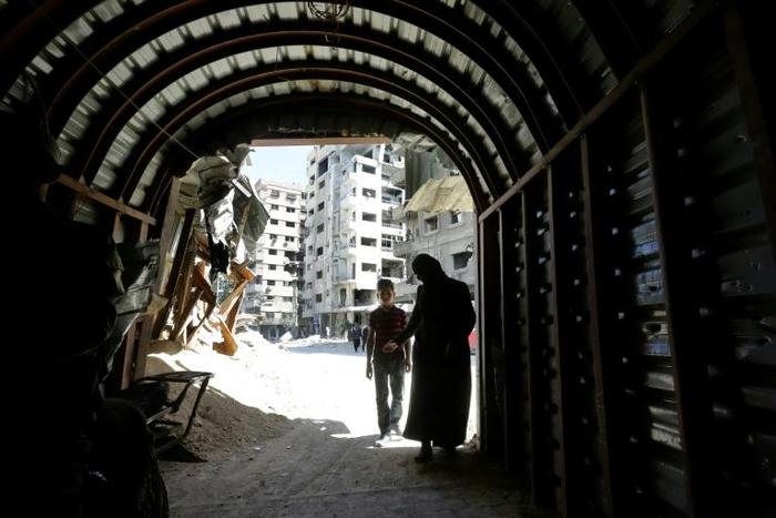 Syrians enter a tunnel leading to an underground hospital in Douma, in eartern Ghouta, a subterranean network of tunnels and makeshift wards and operating rooms beneath the former rebel enclave