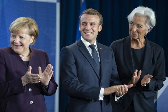 New ECB head Christine Lagarde (right) wants Germany Chancellor Angela Merkel (left) to increase public spending to give the sluggish European economy a boost, a move supported by French President Emmanuel Macon (centre)