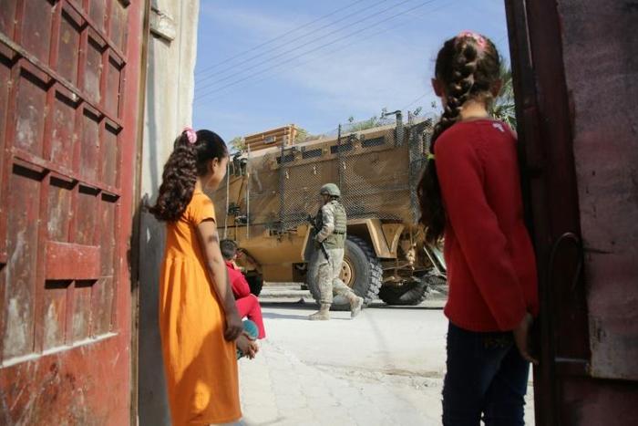 Turkish soldiers patrol the northern Syrian Kurdish town of Tal Abyad near the Turkish border on Wednesday