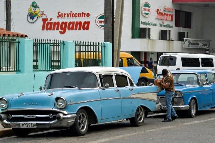 A man uses a funnel to fill his car with fuel from a drum in a Havana street, on September 12, 2019
