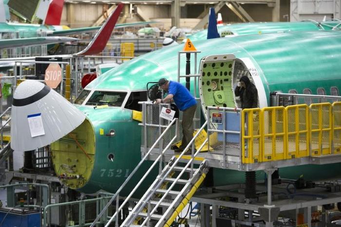 Boeing employees work on a 737 MAX jet at the company's factory in Renton, Washington -- the aviation giant has unveiled a fix to the software system of the jet, which has suffered two deadly crashes in recent months