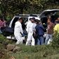A team of forensic experts work in the site where seven bodies were found inside three abandoned vehicles