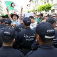 Algerian protesters face riot police during a demonstration in the capital Algiers in June