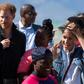Wind and smiles: Prince Harry and his wife Meghan meet members of Waves for Change. The group uses surfing to help young people trapped in Cape Town's slums get a different perspective on life