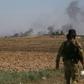 Turkish-backed Syrian fighters watch as smoke billows from the Syrian border town of Tal Abyad