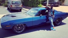 Kevin Hart posses by his classic car