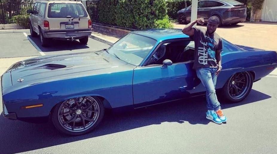 Kevin Hart posses by his classic car