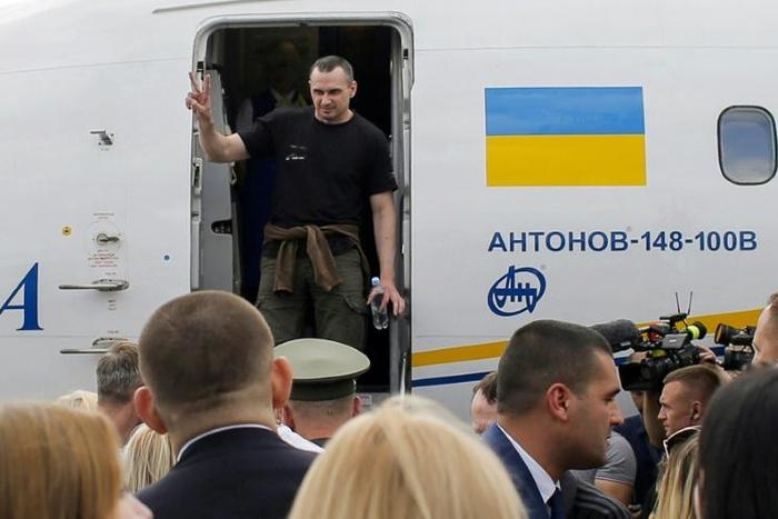 He flashed a victory sign as he disembarked