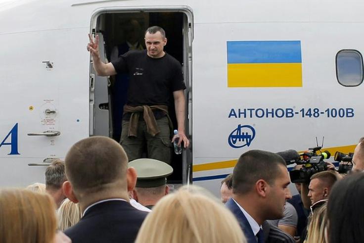 He flashed a victory sign as he disembarked
