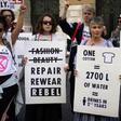 Extinction Rebellion argues that fast fashion is hugely wasteful hold up anti-fashion placards as they block a road on the third day of London Fashion Week in London on September 15, 2019.