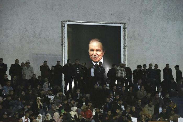 Supporters of Algeria's National Liberation Front (FLN) party, gather at La Coupole arena in the capital Algiers on February 9, 2019, to call upon the current President Abdelaziz Bouteflika (poster) to run for a fifth term in office