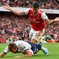 Tottenham striker Harry Kane falls in the area under pressure from Arsenal's Sokratis