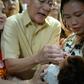 Philippine Health Secretary Francisco Duque (C) administers a dose of oral polio vaccine at the start of a programme to immunise millions of children following the country's first outbreak in nearly two decades