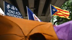 A flag that reads "Hong Kong Independence" is seen alongside the territory's British colonial-era flag and the pro-independence 'Estelada' Catalan flag during a march in Hong Kong on China's national day