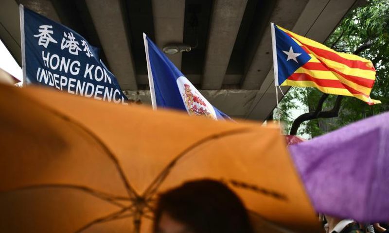 A flag that reads "Hong Kong Independence" is seen alongside the territory's British colonial-era flag and the pro-independence 'Estelada' Catalan flag during a march in Hong Kong on China's national day