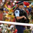 A policewoman patrols past a memorial wall outside the Linwood Mosque in Christchurch on Thursday