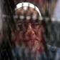 Egyptian Muslim Brotherhood Supreme Guide Mohamed Badie is seen behind bars during a hearing for him and other Brotherhood members on charges of espionage, as the country's crackdown on the Islamist group continues