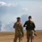 Turkey-backed Syrian fighters watch as smoke billows in the distance during clashes between Syrian regime forces, and Turkish forces, 15kms east of the northeastern town of Ras al-Ein, on October 30, 2019