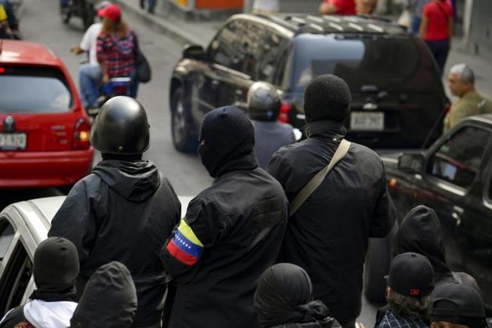 Masked members of a pro-government colectivo cell attend a rally in Caracas on January 7, 2019