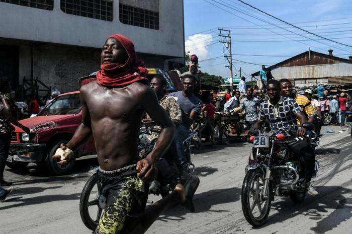 (FILES) In this file photo taken on September 23, 2019 demonstrators march on the street near parliament as they protest against ruling government in Port-au-Prince. The UN has called for calm in crisis-wracked Haiti, eight days before the end of its p...