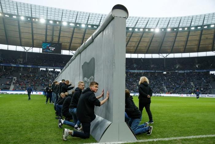 Volunteers prepare to knock down a mock-up of the former Berlin Wall bearing the inscription "Against Walls together with Berlin", before the Bundesliga match between Hertha Berlin and RB Leipzig on Saturday.