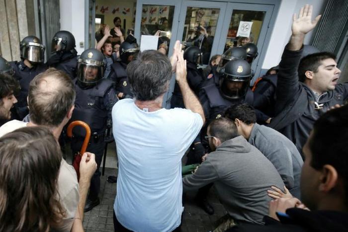 Spanish police officers clash with people outside a polling station in Barcelona, on October 1, 2017, on the day of a referendum on independence for Catalonia banned by Madrid