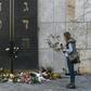 A woman stands next to flowers laid next to the entrance of the synagogue in Munich, dring a protest against anti-Semitism on October 11, 2019 two days after a deadly shooting during an attack in Halle targeting a Turkish restaurant after an attempt at...
